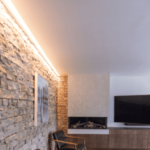 Elegant ambient lighting accentuating a stone feature wall and minimalist modern fireplace in a luxury living room in Wakefield